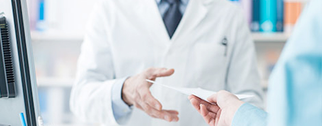 Male pharmacist issuing a prescription